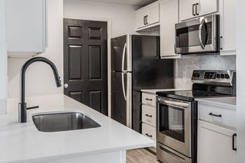 A modern kitchen with a black refrigerator and stove
